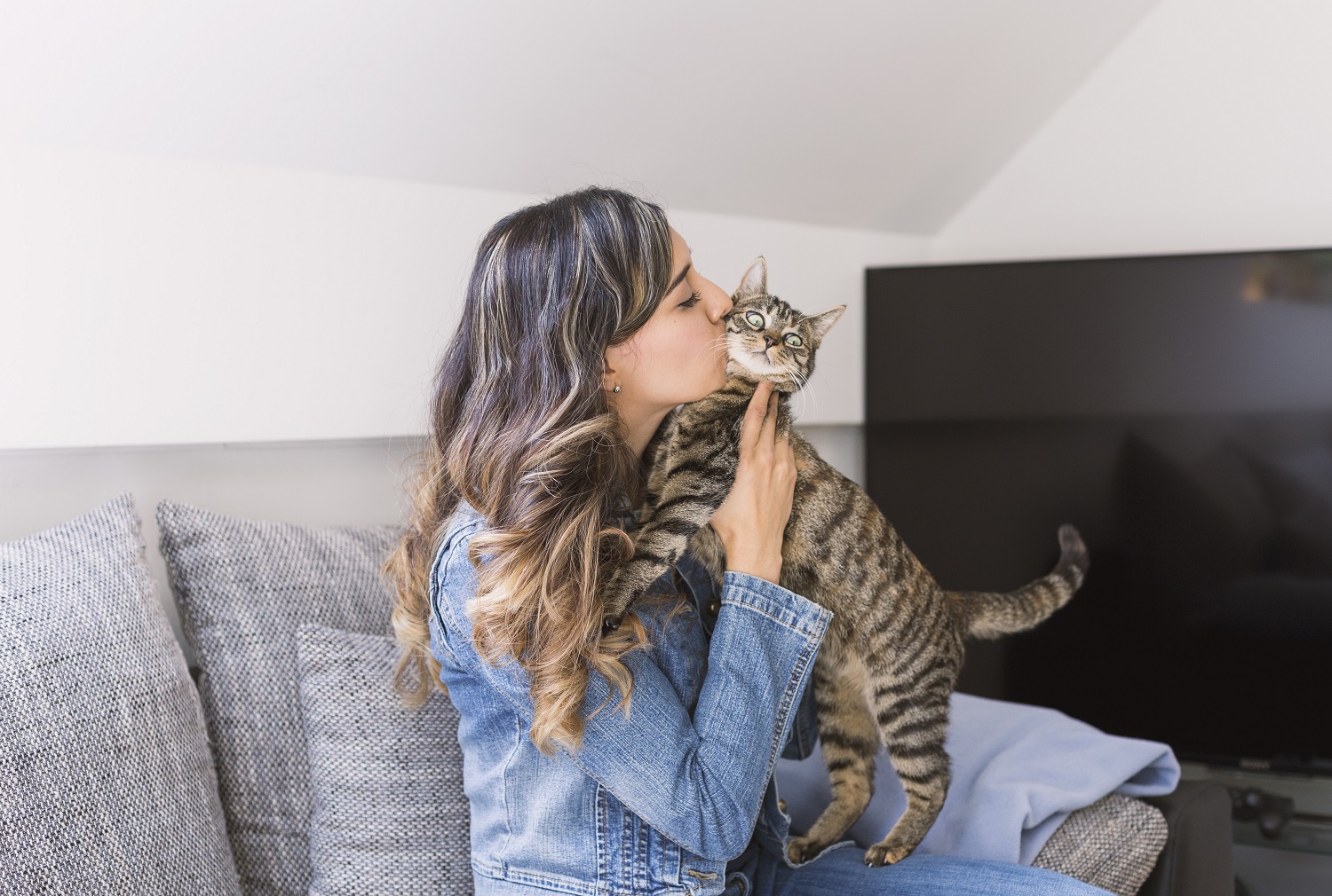 Woman kissing cat
